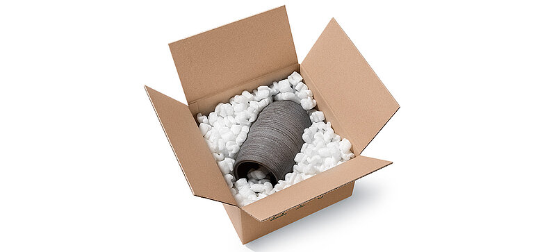 A cardboard box containing porcelain vase and S-shaped organic packaging chips