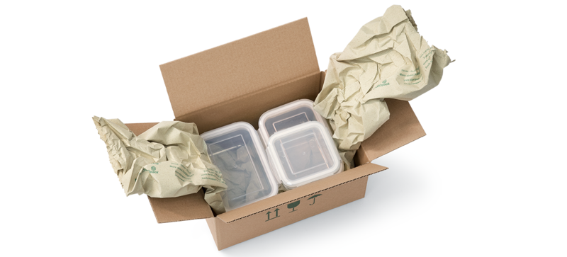 A cardboard box containing food storage containers and paper cushioning strips made from grass paper